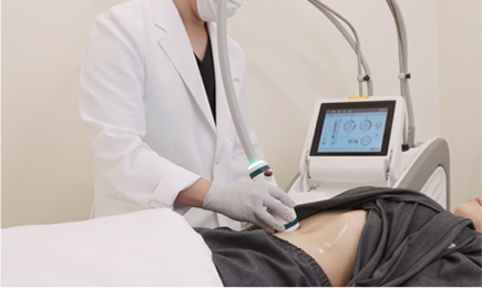 医療スタッフが横になった患者の腹部にボディ機器のハンドピースを当てる様子