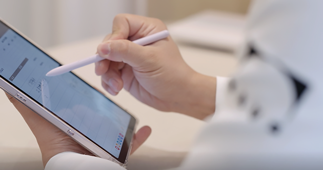 医療スタッフがタブレットにペンで肌の診断内容を確認する手